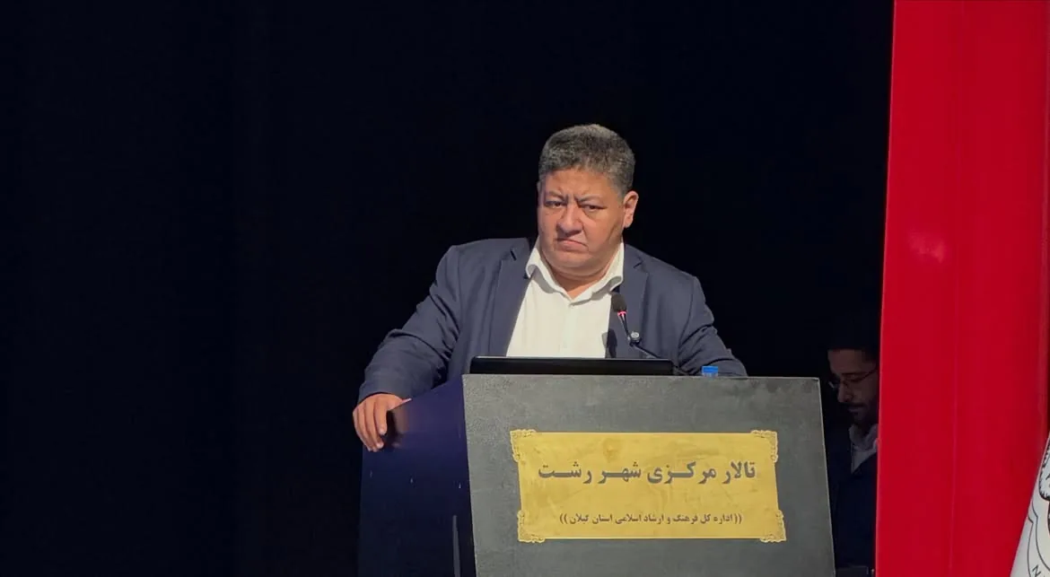 Prof. Guive Sharifi speaking at the podium in Rasht Central Hall