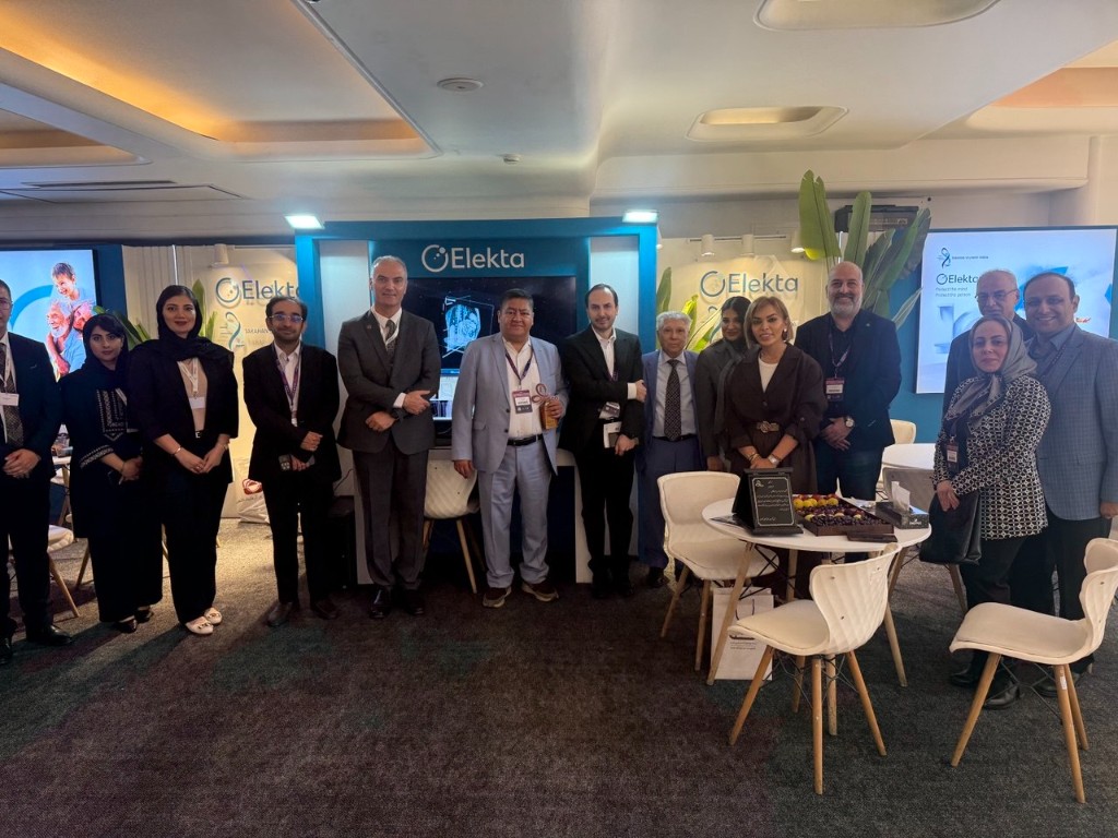 Group photo at the Elekta medical technology booth with brain imaging display