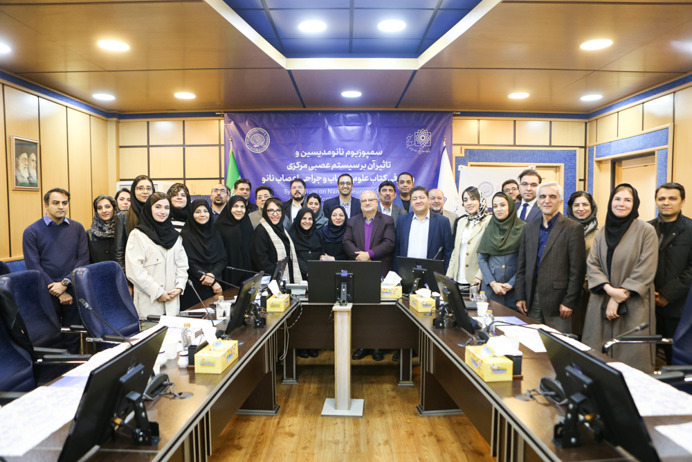 Group photo of symposium participants in front of the event banner at Shahid Beheshti University