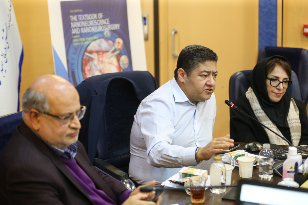 Panel discussion with textbook poster in the background