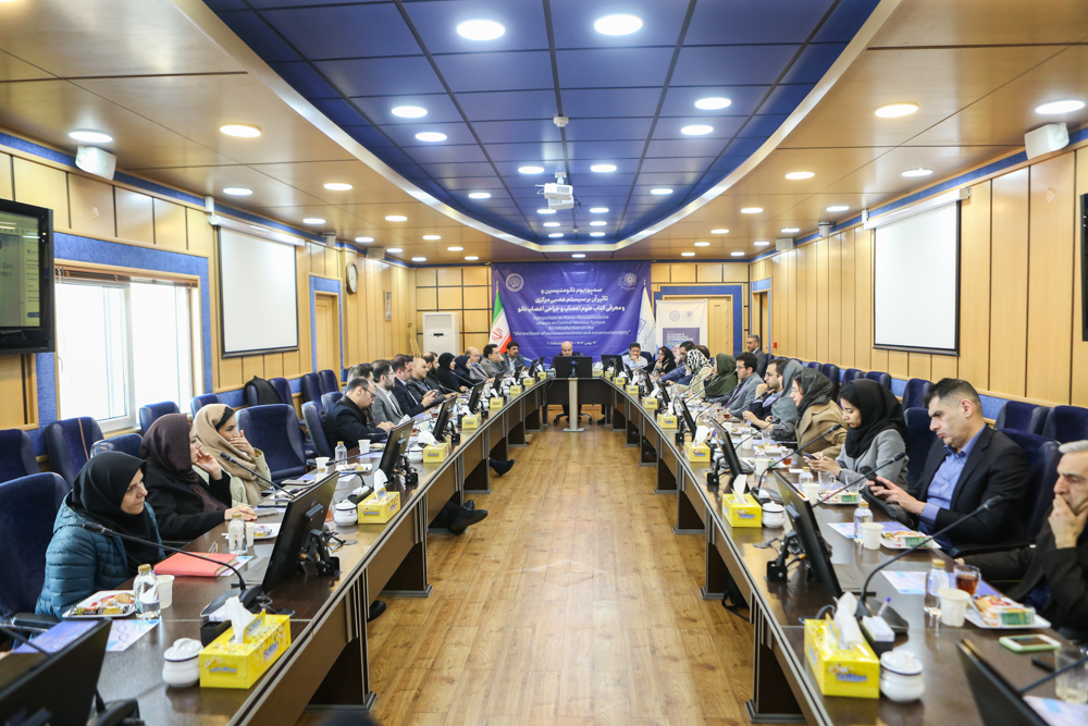 Wide view of the symposium room with attendees seated around the conference table